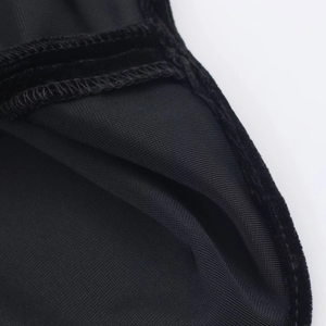 Détail de la texture en velours noir et des coutures du tissu côtelé sur la robe courte