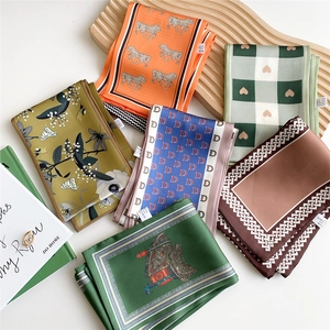 Elegant assortment of printed silk scarves featuring diverse patterns on display tray