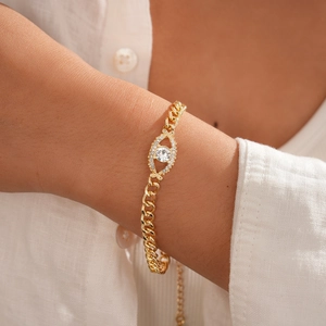 Gros plan d'un bracelet œil porte-bonheur plaqué or avec zircon au poignet