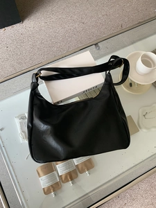 Overhead macro view of black hobo shoulder bag with soft textured leather and gold hardware