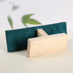 Macro shot of dark green velvet necklace stand with natural solid wood T-bar base