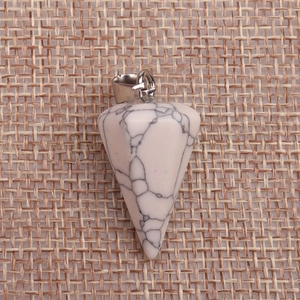 Polished hexagonal white turquoise pendant with natural black veins on brown fabric