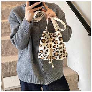 Detail of leopard print faux fur bucket bag featuring gold chain and pearl drawstring