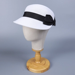 Dettaglio della trama fine in paglia e del fiocco in nastro di raso nero sul cappello bianco