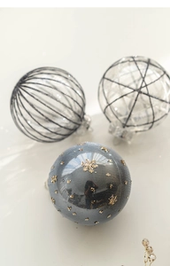 Close-up of 8cm Christmas balls with grey sequins and hand-painted line patterns