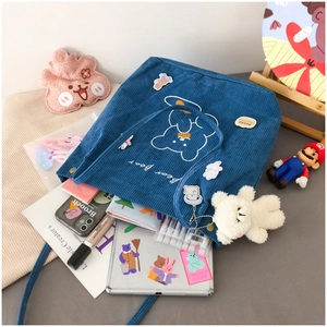 Blue corduroy tote bag detail showing large capacity with bear embroidery and daily items