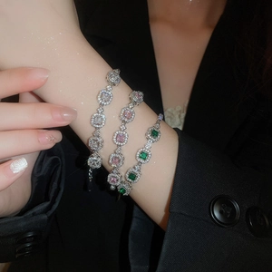 Wrist display of square emerald and pink zircon bracelets with pavé diamonds