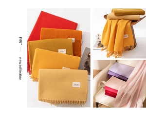 Close-up of knit cashmere-like scarves in multiple colors with elegant long tassels