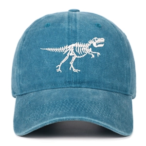 Detail of white dinosaur skeleton embroidery on washed cotton denim baseball cap