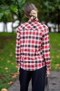Detail view of women's red plaid shirt showing back fit and stitching on flannel fabric