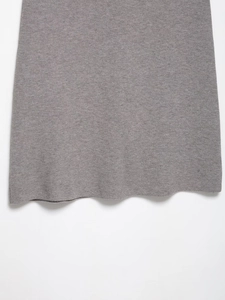 Detailed macro view of the grey knit midi skirt hem showing fine texture and draped edge
