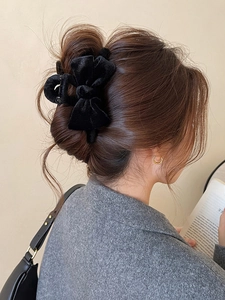 Close-up of a large black velvet bow hair claw clip styled on brunette hair