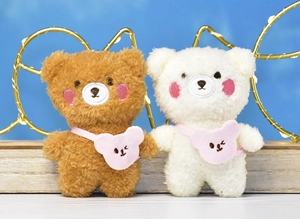 Detailed view of two small plush teddy bears with pink bear-shaped bags and cute embroidery