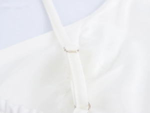 Detail of adjustable metal buckle on white satin camisole straps with fine stitching