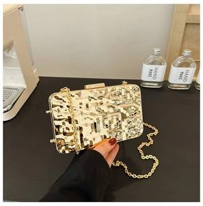 Detail of gold evening clutch bag with metallic pleated texture and elegant chain strap