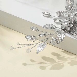 Macro view of silver leaf hair comb with sparkling crystals and elegant white pearls