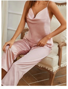 Detail of elegant pink satin pajama set featuring a draped neckline and thin straps