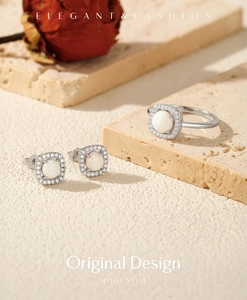 Elegant silver jewelry set with opal ring and earrings on a natural stone base