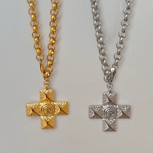 Detail of 18k gold and silver cross pendants with textured Byzantine relief and rolo chain
