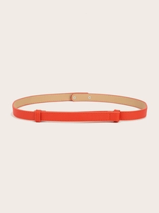 Macro shot of orange cross-textured leather waist belt with sleek metal buckle detail