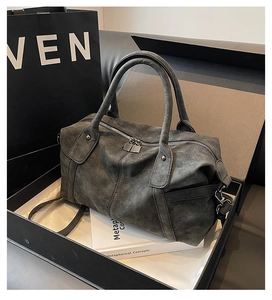 Detail of dark grey frosted leather tote bag with sturdy handles and metal zipper hardware