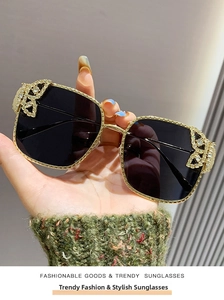 Close-up of golden frame square sunglasses with exquisite rhinestone butterfly details