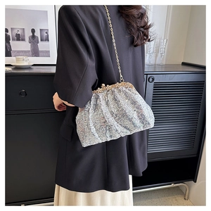 Detail of silver sequin cloud bag with gold pearl clasp and elegant metal chain