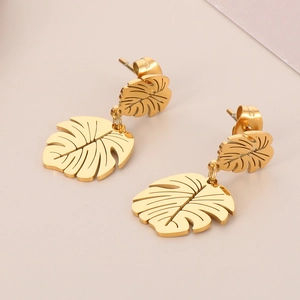 Close-up of gold-plated monstera leaf earrings with hollow vein details and metal studs