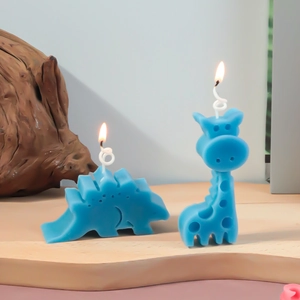 Gedetailleerd zicht op blauwe dinosaurus- en giraffekaarsen op houten display