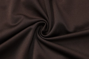 Macro shot of dark brown knitted fabric showing pleated texture and soft drape detail