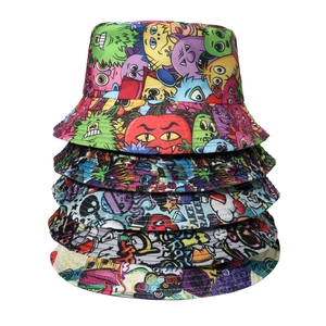 Vertical display of six reversible bucket hats with cartoon monster and graffiti prints