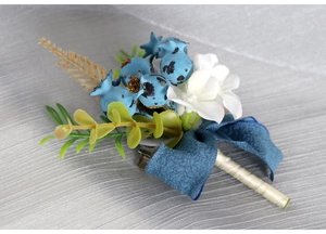 Detailed view of forest-style boutonniere with blue berries and eucalyptus leaves