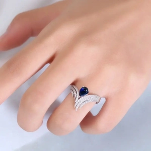 Détail macro de la bague ailée avec pierre bleue en goutte et zircons scintillants
