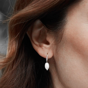 Close-up of elegant s925 silver pearl drop earrings with cubic zirconia worn on ear