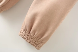Detail of beige faux suede jacket showing soft texture and elastic ribbed cuff