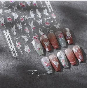 Detail of 5D embossed nail stickers featuring red roses, white butterflies, and lace trim