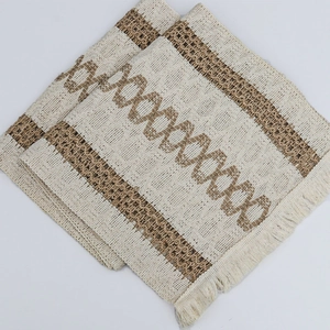 Close-up of cotton linen table mat with bohemian geometric patterns and fringe edges