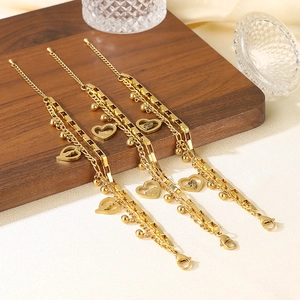 Detailed view of layered gold heart bracelets on a wooden stand for Mother's Day gifts