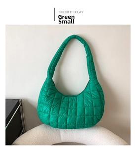 Detail view of the green quilted pattern and soft texture on this padded shoulder bag