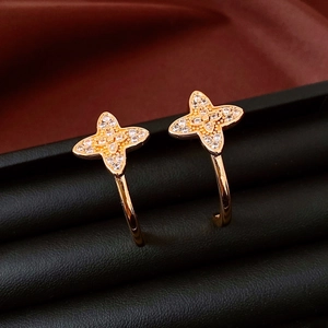 Macro detail of vintage gold C-shape flower earrings with shimmering white zircon stones