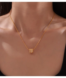 Close-up of gold-plated cylinder pendant with sparkling cubic zirconia on a necklace
