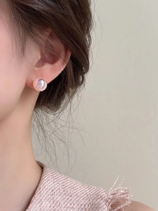 Detail view of pink mermaid pearl stud earring on model showing soft luster and elegant style
