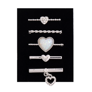 Close-up of 5-piece silver watch band charms with hearts and rhinestones on black card