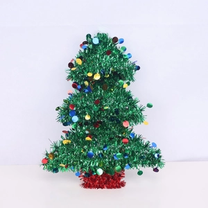 Mini tabletop Christmas tree with colorful sequins and red base on white background