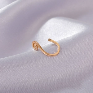 Detail of gold-plated U-shaped faux nose ring with vintage spiral texture on white silk