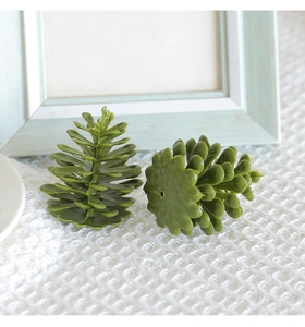 Detailed view of green artificial pine cones on white lace for Christmas DIY decor