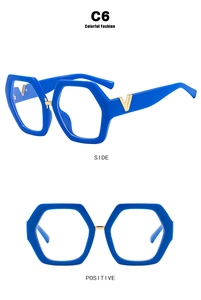 Detail view of stylish blue hexagonal glasses frames featuring gold V-shaped temple accents