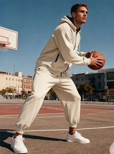 Dettaglio della tuta da uomo in pile color crema con felpa con cappuccio e pantaloni jogger