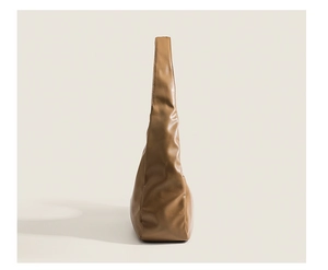 Side view of soft brown leather hobo bag showing spacious capacity and smooth texture