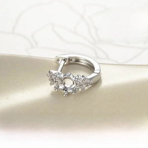 Macro detail of 4mm silver earring setting with hand-set cubic zirconia accents